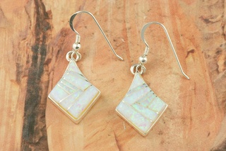 Stunning Fire and Ice Lab Opals inlaid between ribbons of Sterling Silver. Beautiful Sterling Silver French Wire Earrings feature precision channel inlay. Designed by Navajo Artist Calvin Begay. Signed.